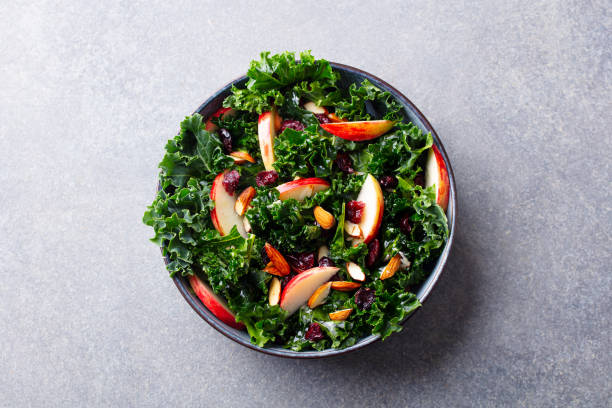 istock Kale salad with apples, cranberry and nuts. Grey background. Top view. 1214757778