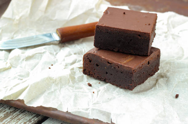 Sliced chocolate muffin on the wooden board in paper wrapper