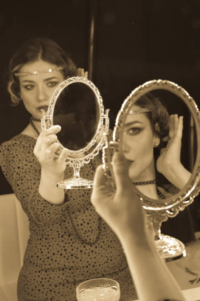 istock Woman in 1920s looking herself in the mirror 1214758427