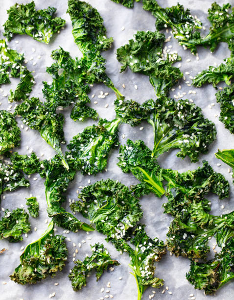 istock Kale chips, healthy snack on parchment paper. Top view. 1214758623