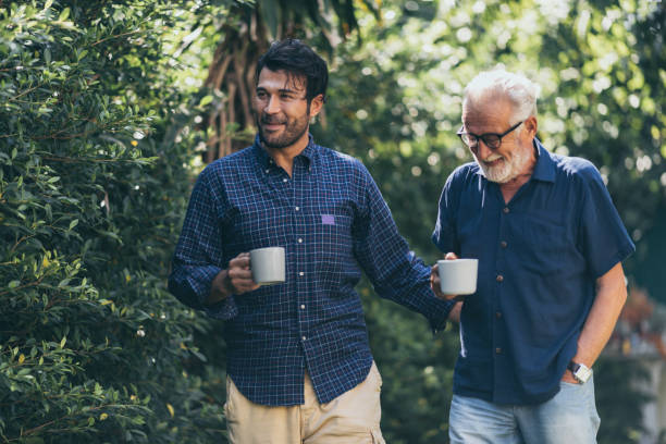 istock Father-son bonding. Cheerful young man drinking coffee together with him 1214759192