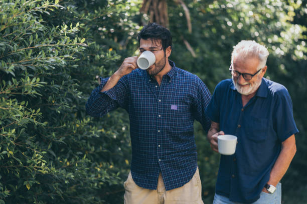 istock Father-son bonding. Cheerful young man drinking coffee together with him 1214759220