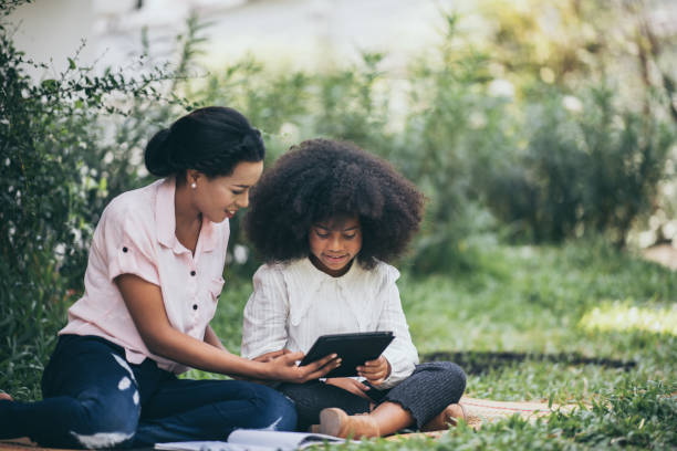 istock Mother is teaching daughter's homework through Tablet 1214760898