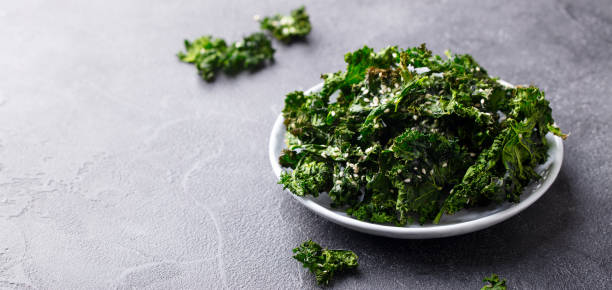 istock Kale chips, healthy snack on a plate. Grey background. Copy space. 1214760944