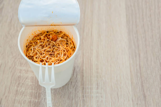 istock Hot noodle Cup. Noodle cup Ready made. Eating Instant Noodles with a Plastic Fork. Junk food Instant noodles are eating the popular food. 1214761034