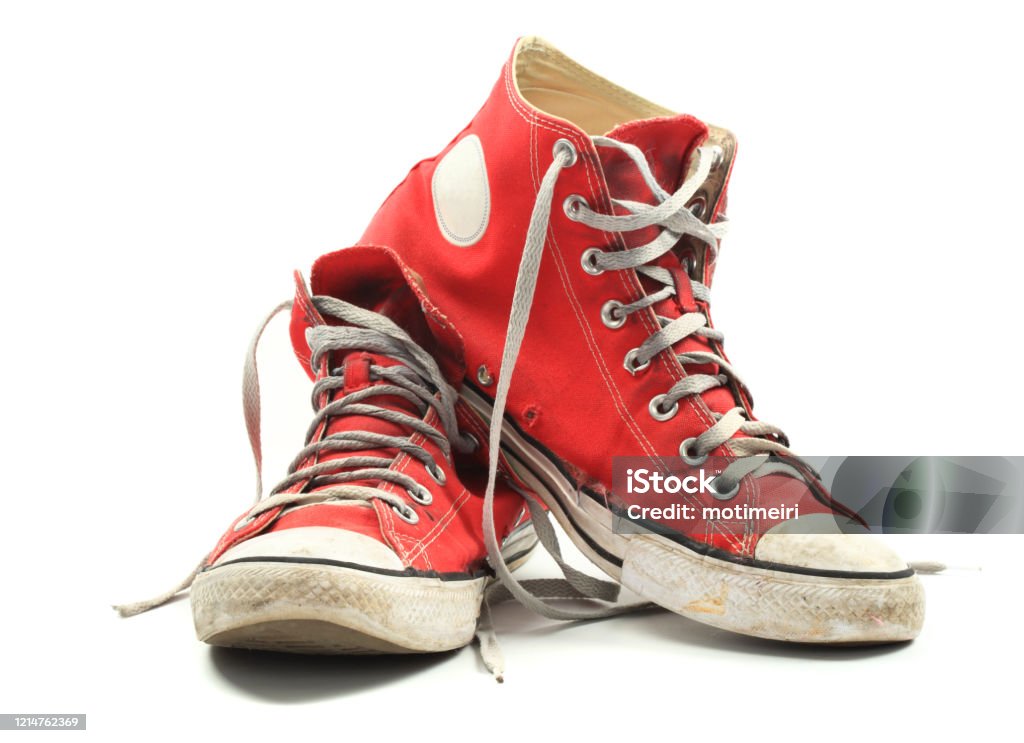 Old canvas sneakers Old and dirty red canvas sneakers, isolated over white Shoe Stock Photo