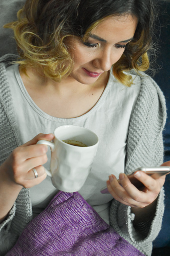Woman indoors drinking coffee