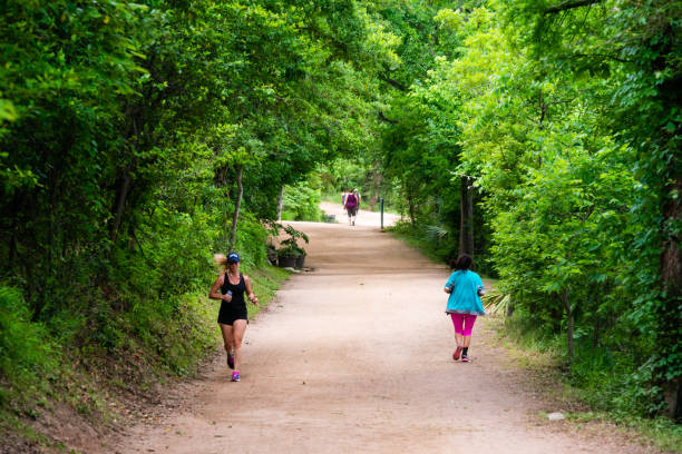 In Austin, United States people walk along a dirt trail outdoors on a spring day.