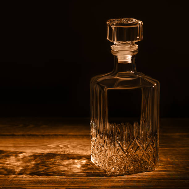 istock An elegant empty carafe, on a textured wooden table. Decanter in dark style. 1214765678