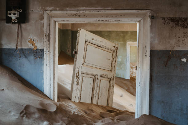 porta deixada preso na areia do deserto dentro de casa velha - luderitz city - fotografias e filmes do acervo