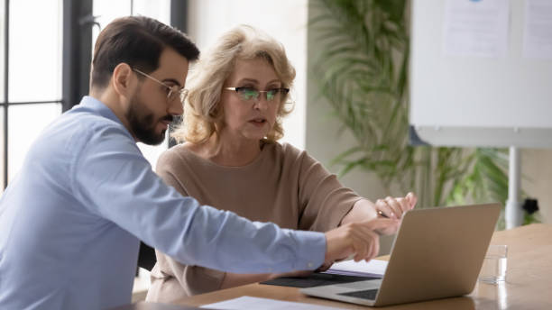 istock Focused diverse businesspeople discuss ideas working on laptop 1214766080