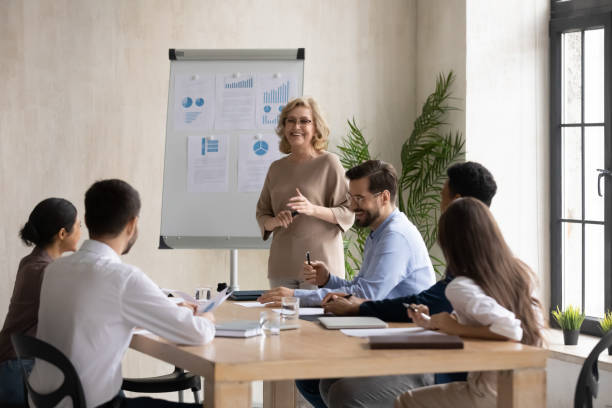 istock Happy middle-aged businesswoman make whiteboard presentation at briefing 1214766081