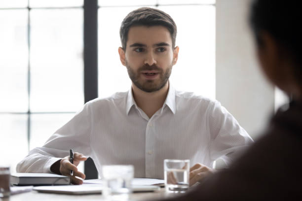 istock Focused male employee discuss project with business partner 1214766139