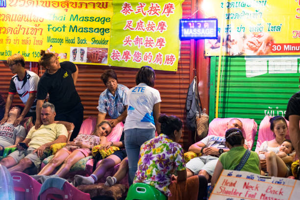 Phuket, Thailand, February 20, 2018: Employees sit at the entrance to the massage parlor and await customers.