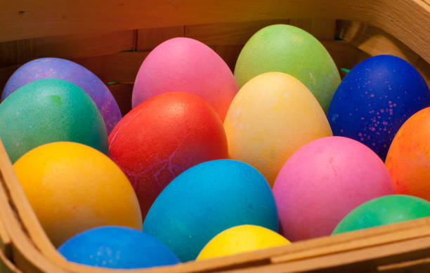 vista lateral de una cesta de madera que contiene huevos temunados multicolores - carton multi colored easter egg easter fotografías e imágenes de stock