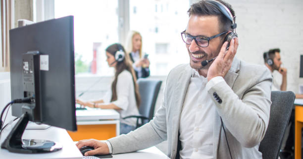 istock Confident male customer support operator with headset working in call center 1214768119