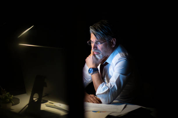 istock Serious businessman thinking of problem solution working late in office 1214768127