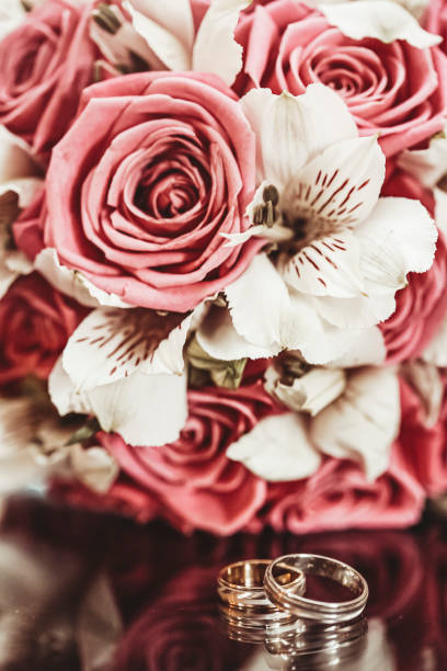 istock Two wedding rings and a bridal bouquet in the background 1214773432