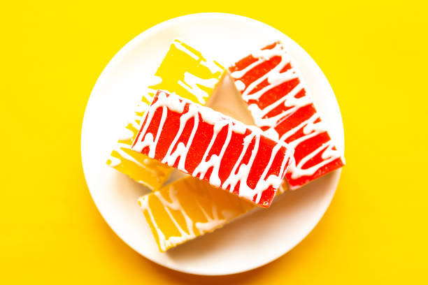Delicious cakes on a plate, top view. Bright yellow background, minimal