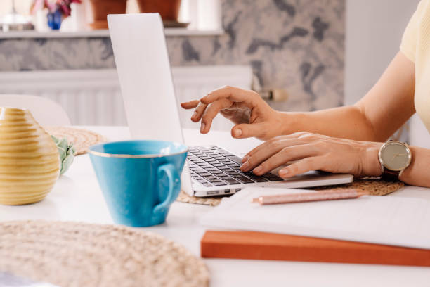 istock Woman working on laptop at home focus on hands 1214774755