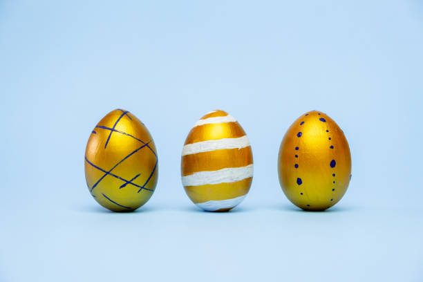 istock Happy Easter. Three easter eggstrendy colored classic blue, white and golden on blue background. Copy space. Minimal style 1214776305