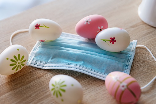 Easter egg and medical protective mask on the table. Easter during coronavirus covid-19 pandemic.