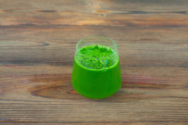 istock Green herb smoothie on  wooden brown table 1214776903