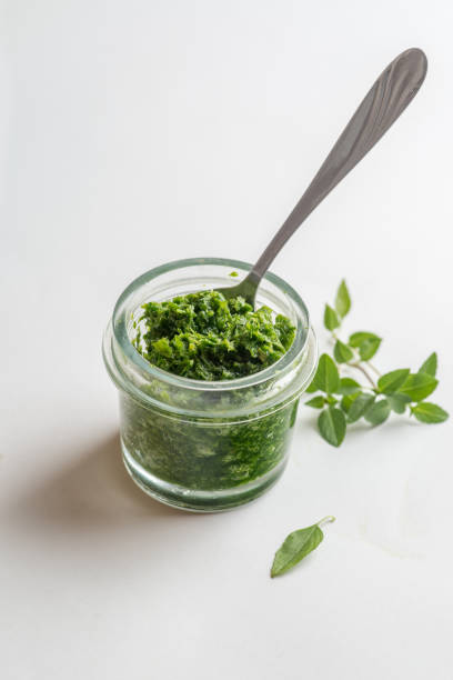 istock pesto sauce in a jar take a spoon. Close shot 1214778260