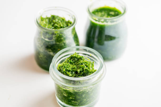 istock Pesto sauce in three jars on a white background 1214778272