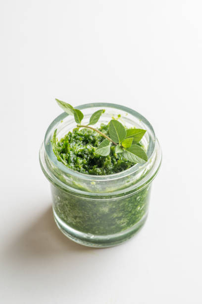 istock pesto sauce in a jar on a white background 1214778473