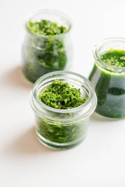 istock Pesto sauce in three jars on a white background 1214778522