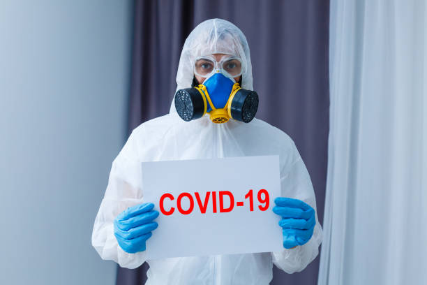 istock Man wearing chemical protective suit on light grey background. Coronavirus outbreak 1214781260