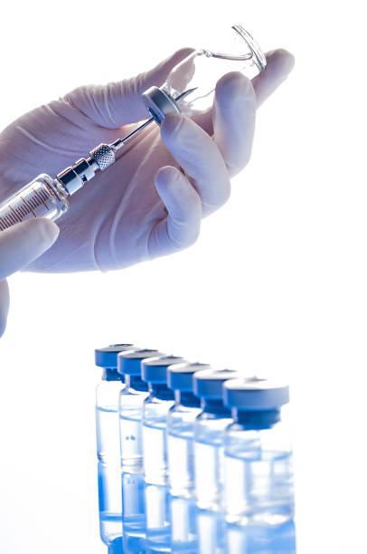 istock Preparing vaccine: Hands with gloves holding syringe and vial 1214783330