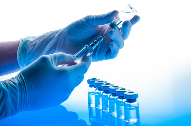 istock Preparing vaccine: Hands with gloves holding syringe and vial 1214783337