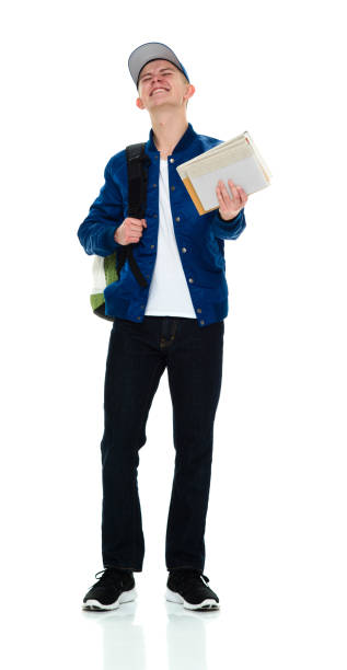 istock Young male high school student standing wearing backpack and holding book 1214784823