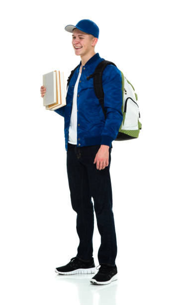 istock Young male university student standing wearing backpack and holding book 1214784856