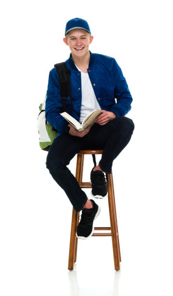 istock Teenage boys university student sitting wearing backpack and holding book 1214784870
