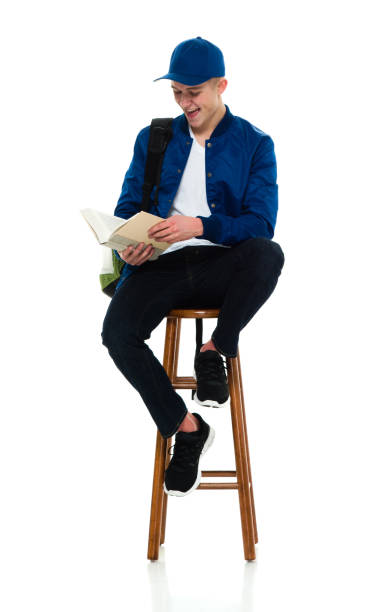 istock Young male high school student sitting wearing backpack and holding bag 1214784906