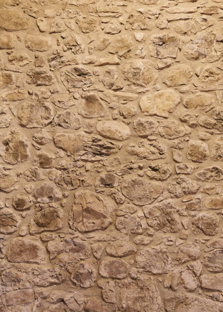 Old dirty background of brown wall with small and big stones
