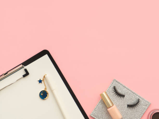 istock Beauty composition with a clipboard, pen on it, curative, decorative cosmetics and accessories on pink background with copy space. 1214788549