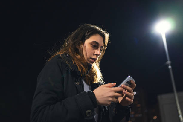 istock Scared young woman calling for help on mobile phone while wandering around city 1214793336