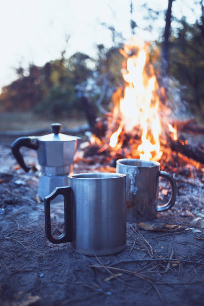 happy trip - bonfire and geyser coffee maker with cup in the foreground \