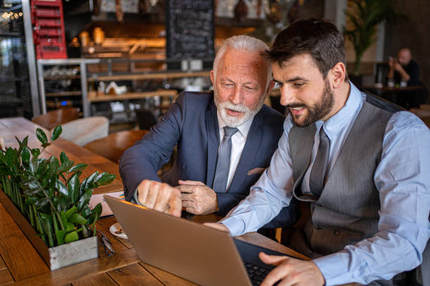 istock Senior businessman showing data analyze on a laptop to his apprentice 1214796870