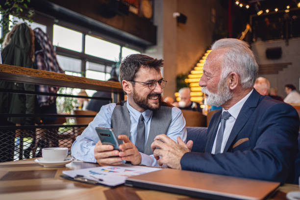 istock Senior manager using his coffee break to laud a younger colleagues hard work 1214796884