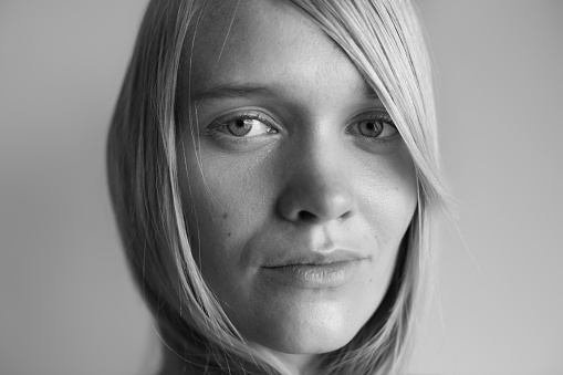 A portrait of a beautiful blonde looking into the camera in black and white.