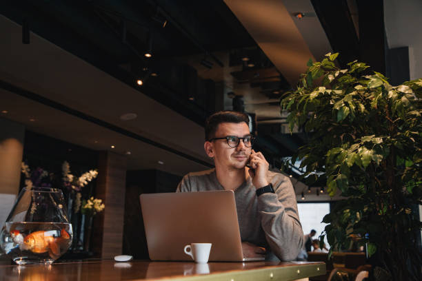 istock Handsome young businessman talking on a mobile phone while working 1214797695