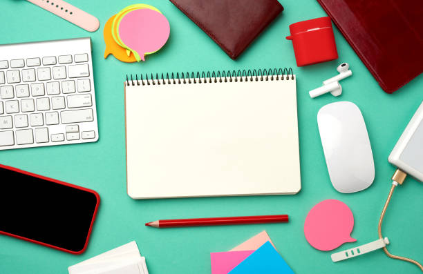 istock paper notebook, keyboard, power bank with cable, red smartphone with blank black empty screen 1214799972
