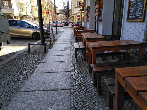 Deserted street with closed restaurants in Friedrichshain, Berlin during coronavirus shutdown in Germany Berlin, Germany - March 25, 2020: Empty restaurant tables on a deserted street in the normally lively Friedrichshain district of Berlin during coronavirus shutdown in Germany. friedrichshain photos stock pictures, royalty-free photos & images
