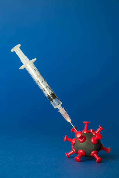 istock Syringe with liquid medicine shot to corona virus cell minimal creative concept. Space for copy. 1214802334