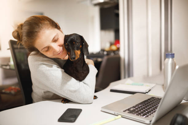 istock Pet owner embracing her dog while doing home office 1214808035